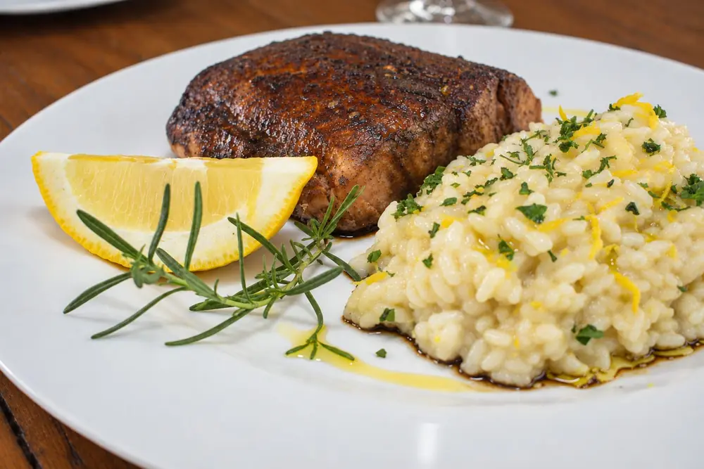 Salmão grelhado com risoto de limão e um ramo de alecrim
